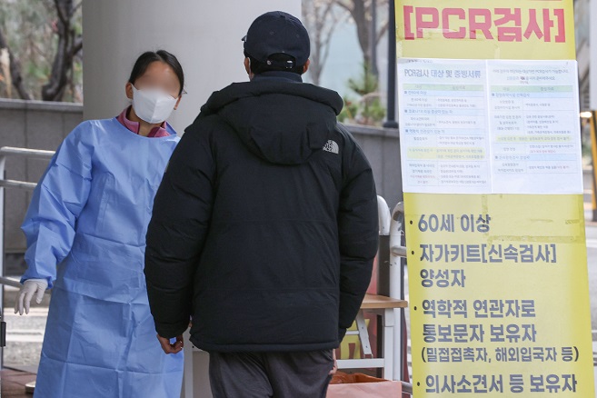 A medical workder guides a person at a COVID-19 test center in Seoul's Mapo district on Nov. 23, 2022. (Yonhap)