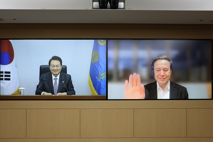 President Yoon Suk-yeol (L) is seen at the presidential office in Seoul during a virtual meeting with Tesla CEO Elon Musk on Nov. 23, 2022, in this photo provided by the office.