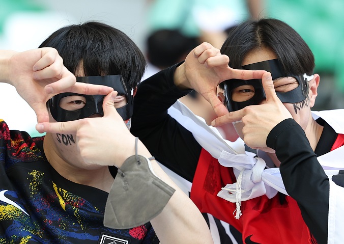 Fans of the South Korean national football team pose in custom-made mask in show of support for captain Son Heung-min before South Korea's Group H match against Uruguay at the FIFA World Cup at Education City Stadium in Al Rayyan, west of Doha, on Nov. 24, 2022. (Yonhap)
