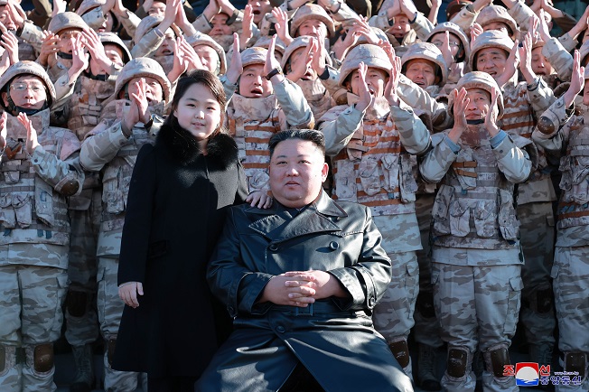 This photo, released by the Korean Central News Agency on Nov. 27, 2022, shows North Korean leader Kim Jong-un (front, R) with his daughter during a photo session with officials involved in this month's intercontinental ballistic missile launch. (Yonhap)