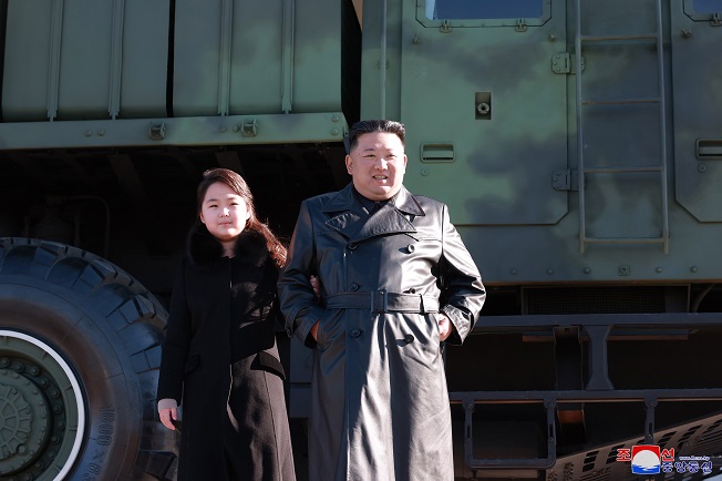 This photo, released by the Korean Central News Agency on Nov. 27, 2022, shows North Korean leader Kim Jong-un (R) with his daughter during a photo session with officials involved in this month's intercontinental ballistic missile launch. (Yonhap)