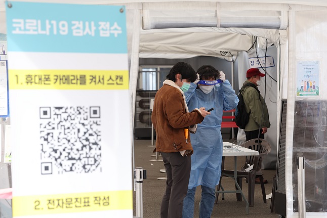 A citizen talks to a medical worker at a COVID-19 testing center in Seoul on Nov. 27, 2022. (Yonhap)