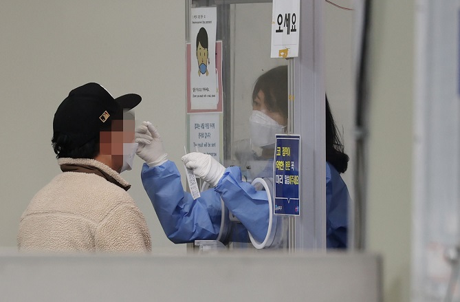 A person receives a PCR test for COVID-19 at a testing center in Seoul on Nov. 30, 2022. (Yonhap)