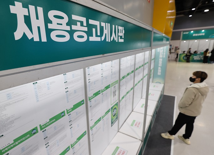 A job seeker reads notices on a bulletin board at a job fair held in Seoul on Nov. 30, 2022. (Yonhap)
