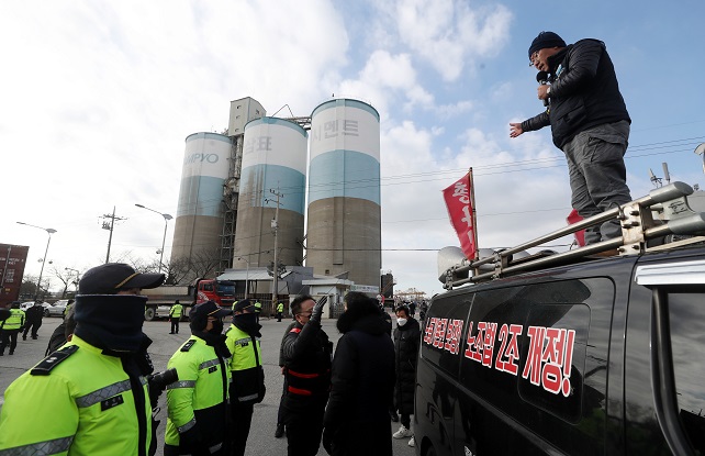 Police confront a striking union member of the Cargo Truckers Solidarity Union at the operation site of Sampyo Cement Co. in Incheon, 27 kilometers west of Seoul, on Dec. 1, 2022. (Yonhap)