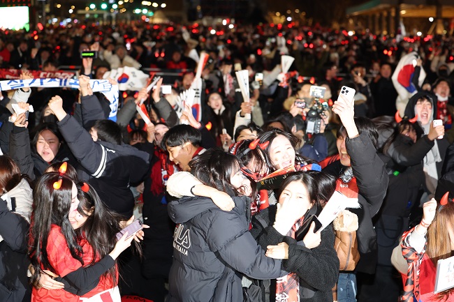 Red Devils, the supporting group for South Korea's national soccer team, cheer with joy at Seoul's central Gwanghwamun on Dec. 3, 2022, after the team clinched a 2-1 win over Portugal in the final Group H match at the FIFA World Cup in Qatar. (Yonhap)