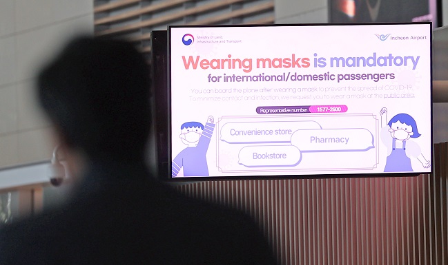 A notification asking people to wear masks indoors is shown on a screen inside Incheon International Airport on Dec. 11, 2022. (Yonhap)