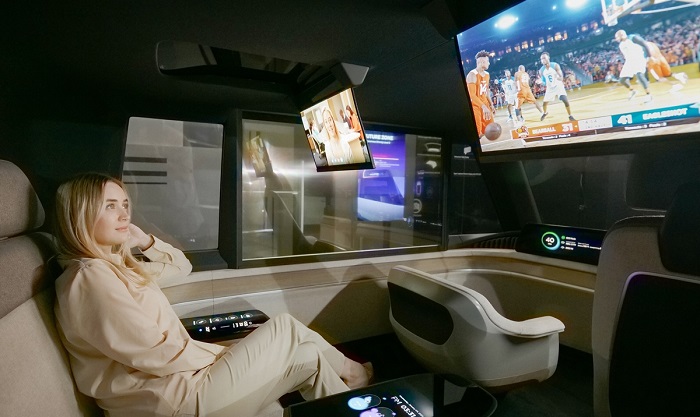 The photo provided by LG Display Co. on Jan. 5, 2023, shows a passenger watching a sports program on a rollable panel inside the company's autonomous concept car.