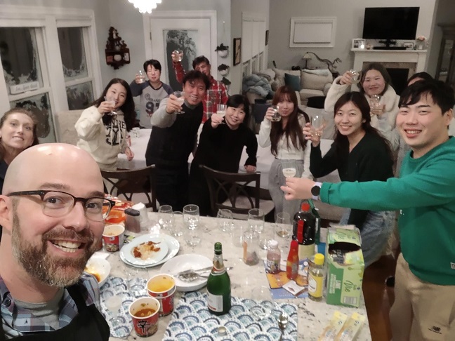 In this photo posted on the Facebook account of Alexander Campagna, he, his wife and 10 stranded travelers from South Korea pose for a photo after a dinner party on Dec. 24, 2022. (Yonhap)