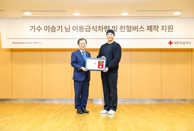 Singer Lee Seung-gi (R) and Shin Hee-young, chief of the Korean Red Cross, pose for a photo during a ceremony for Lee's donation of 550 million won at its office in Seoul on Jan. 13, 2023, in this photo provided by the humanitarian organization.