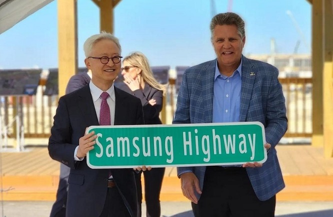 The photo, taken from an Instagram post by Samsung Electronics Co. co-CEO Kyung Kyu-hyun on Jan. 15, 2023, shows him holding a Samsung Highway road sign with Williamson County Judge Bill Gravell. (Yonhap)