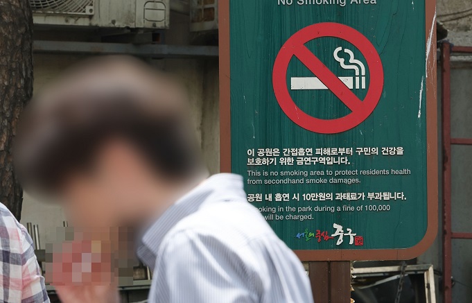 This file photo taken May, 31, 2022, shows a person smoking at a park in Seoul. (Yonhap)