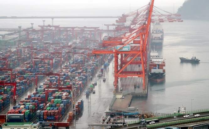 This file photo, taken Dec. 21, 2022, shows container ships being loaded with cargo at a port in South Korea's largest port city of Busan. (Yonhap)