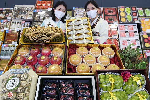 Models pose with gift packages composed of agricultural products for the Lunar New Year, in this file photo released by NH Nonghyup Hanaro Mart on Dec. 27, 2022.