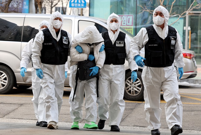 In this file photo, a 41-year-old Chinese man (2nd L) is taken to a hotel, designated by the government as a temporary quarantine facility for entrants from China, in Incheon, 27 kilometers west of Seoul, on Jan. 5, 2023, two days after he escaped from the hotel following the detection of his COVID-19 infection upon entering South Korea via Incheon International Airport. South Korea began to require a PCR test for all entrants from the neighboring country on Jan. 2. (Yonhap)
