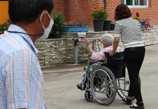 A 70-year-old son looks at his 104-year-old wheelchair-bound mother at a senior care hospital in Sangju, North Gyeongsang Province in this file photo taken on Sept. 14, 2021. (Yonhap)
