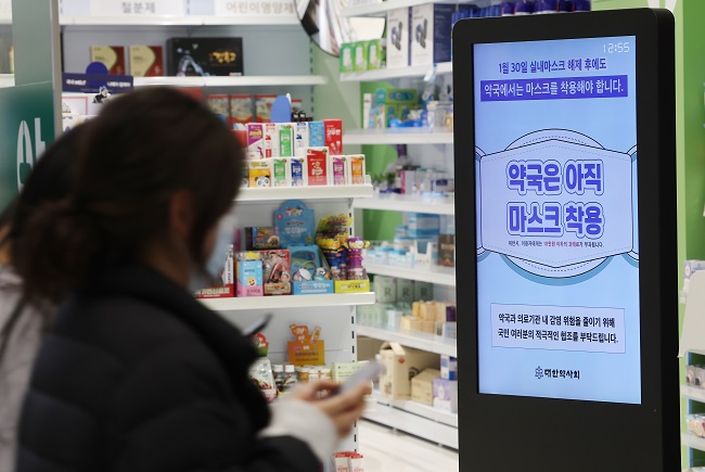 A notice in front of a pharmacy inside Incheon International Airport shows a mask-wearing mandate still in effect at pharmacies on Jan. 31, 2023. (Yonhap)