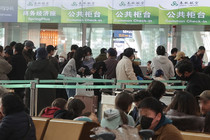 Travelers heading to the Chinese city of Shenyang wait in line at the departure lobby of Terminal 1 of Incheon airport, west of Seoul, on Feb. 1, 2023. (Yonhap)