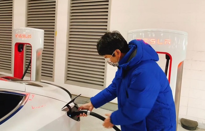 In this photo taken in February 2021 and provided by Mark Woo, he charges his Model 3 Performance model at a Tesla supercharger station at the Lotte shopping mall in Gimpo International Airport, just west of Seoul. (Yonhap)