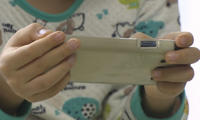 A toddler uses a smartphone in this file photo provided by Yonhap News TV.