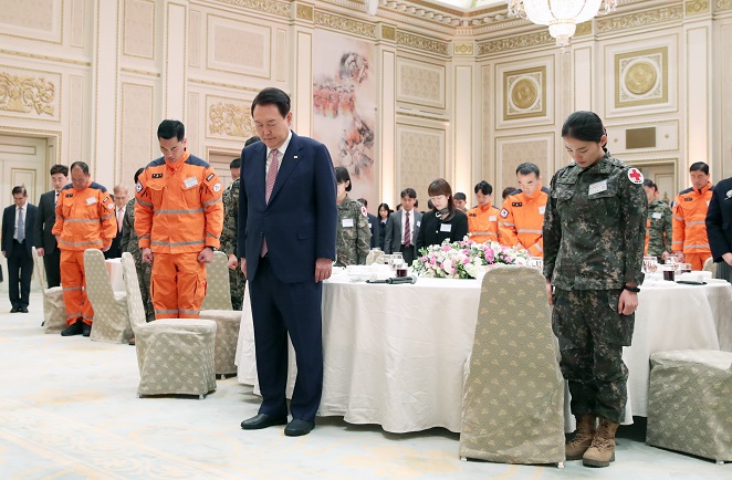 President Yoon Suk Yeol (2nd from R) and a South Korean rescue team that was dispatched to Turkey following a devastating earthquake pay silent tribute to the quake's victims during a luncheon meeting for the contingent at the guesthouse of the former presidential office, Cheong Wa Dae, in Seoul on March 7, 2023. (Pool photo) (Yonhap)