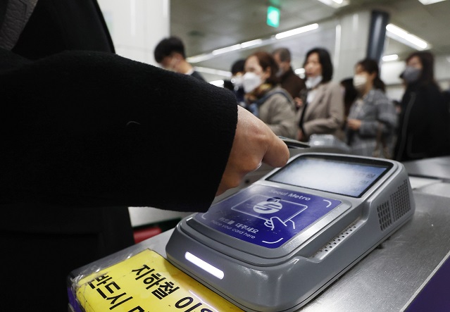 A passenger touches a transportation card to the card reader on a turnstile at a subway station in Seoul on March 15, 2023. The government said South Korea will end the mask mandate for public transportation next week, lifting one of the last-remaining COVID-19 restrictions amid a stable virus situation. (Yonhap)
