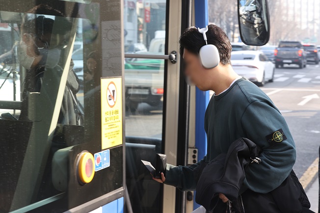 This file photo shows a person without a mask getting on a bus in Seoul on March 20, 2023, as the government lifted the mask mandate on public transportation. (Yonhap)