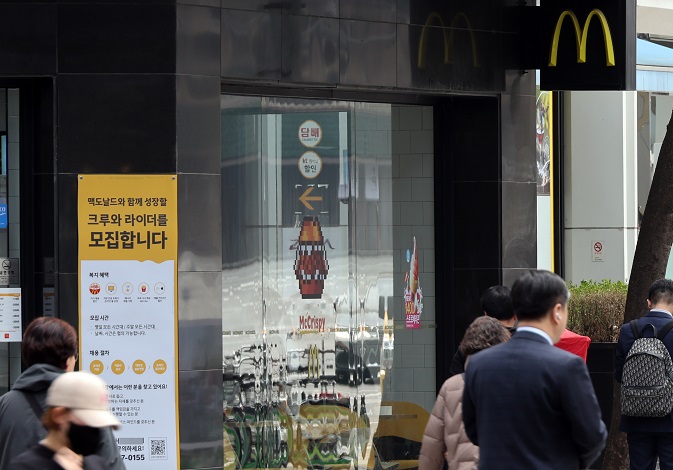 People walk past a McDonald's restaurant in Seoul on March 22, 2023. (Yonhap)