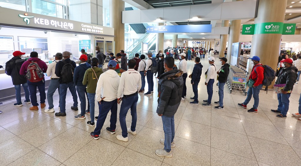 Travelers from Sri Lanka line up in front of a currency exchange booth to exchange money at the arrival hall of Incheon International Airport's Terminal 1. (Image courtesy of Yonhap)