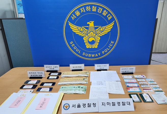 This undated photo, provided by the Seoul Subway Police, shows cash, mobile phones and other objects the police seized from the leader of a phone theft ring.