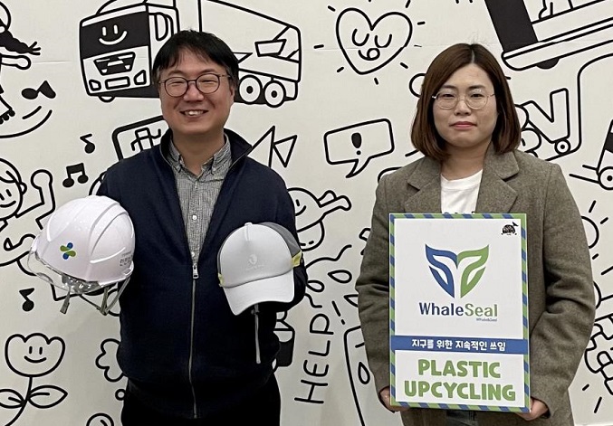 Usisan CEO Byun Ui-hyun (L) is holding lightweight safety helmets in this photo provided by SK Innovation Co.
