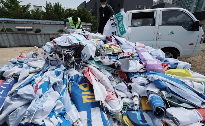 In this file photo, city officials are shown collecting discarded banners. (Yonhap)