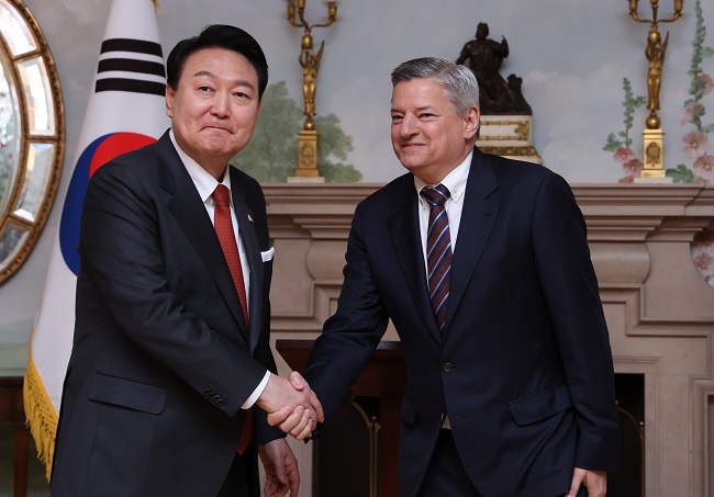 President Yoon Suk Yeol (L) shakes hands with Netflix co-CEO Ted Sarandos after the company announced plans to invest US$2.5 billion in South Korea over the next four years, at Blair House in Washington on April 24, 2023. (Yonhap)