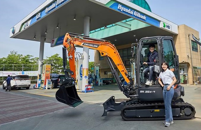 HD Hyundai Infracore Co.'s mini excavator stands in front of HD Hyundai Oilbank Co.'s gas station in this photo provided by HD Hyundai Oilbank.