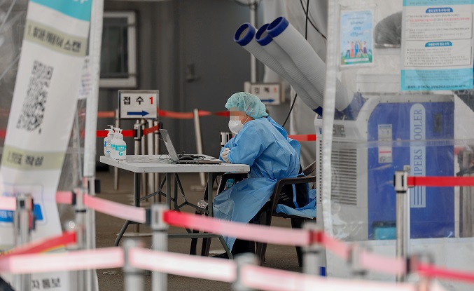 This file photo, taken May 11, 2023, shows a medical worker in a blue gown at a COVID-19 testing center at Seoul Station in central Seoul. (Yonhap)
