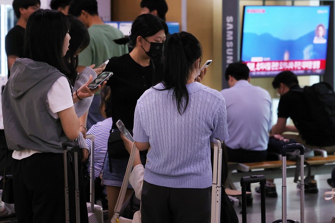 A group of students on a school trip checks an emergency alert on their smartphones, which urged Seoul residents to take shelter, at Seoul Station in the capital on May 31, 2023, shortly after the Joint Chiefs of Staff said it detected the launch of what it claims to be a "space launch vehicle" southward from Dongchang-ri on the North's west coast at 6:29 a.m. The alert issued by the Seoul metropolitan government was later retracted. (Yonhap)