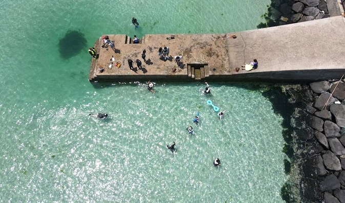 Tourists snorkel in waters near a port in the city of Jeju on South Korea's largest island of the same name on June 7, 2021. (Yonhap)