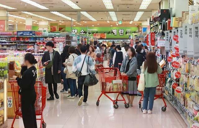 People shop for groceries at a supermarket in Seoul on May 8, 2023. (Yonhap)