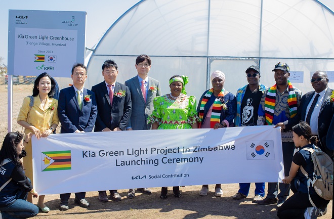 Officials pose for a photo during the launch ceremony of the Green Light Project in Zimbabwe in this photo provided by Kia Corp.