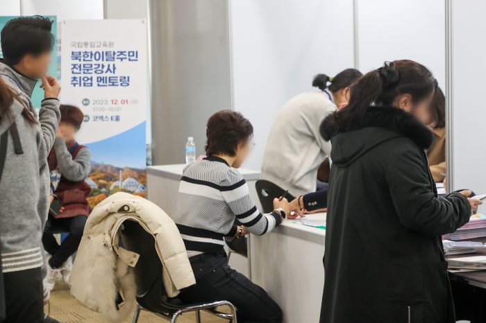 A job fair participant visits a booth at the event for North Korean defectors in South Korea at the COEX exhibition center in Seoul on Dec. 1, 2023. (Yonhap)