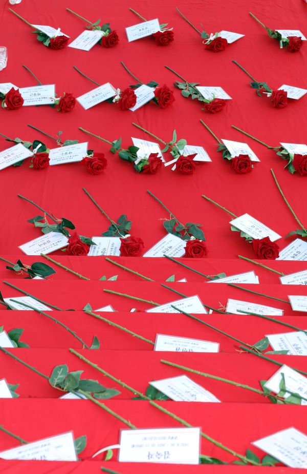 Behind the press conference, roses and name tags lay in memory of Homeless, who died in squalor.  233333