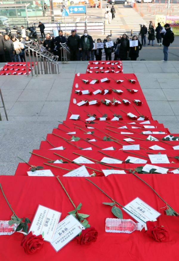 Behind the press conference, roses and name tags lay in memory of Homeless, who died in squalor.  3737