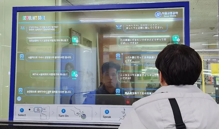 A Japanese man asks, "How do I get to Incheon Airport?" using the Foreign Language Simultaneous Conversation System installed at Myeongdong Station on Seoul Subway Line 4. The Myeongdong station staff replies in Korean, "You can go to Seoul Station and change to the airport train," which is immediately translated into Japanese on the screen.