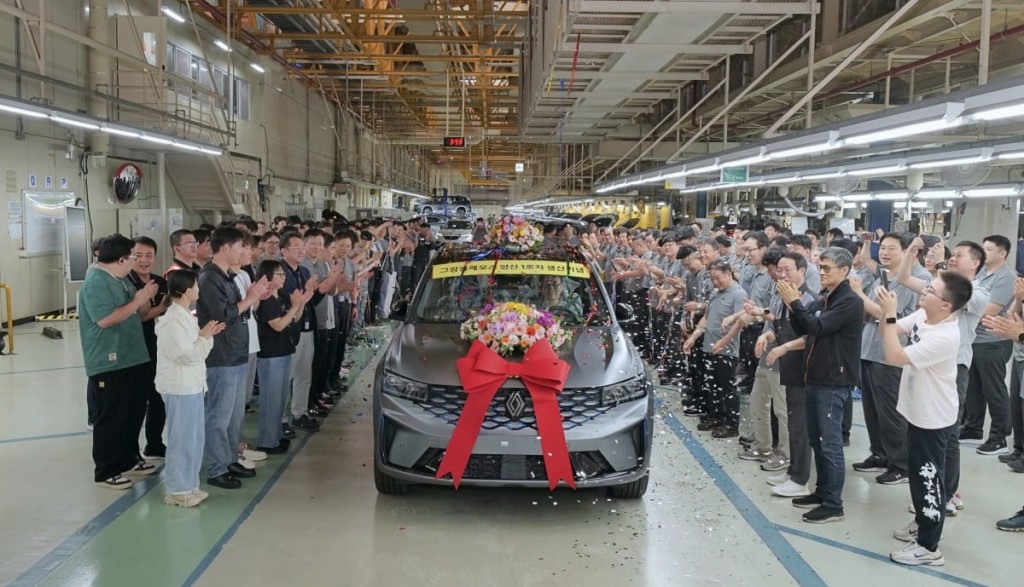 This photo, provided by Renault Korea Motors Co., shows company officials posing for a photo during a celebration for the first unit of the Grand Koleos at its manufacturing plant in Busan, some 320 kilometers southeast of Seoul, on July 15, 2024.  (Image courtesy of Renault Korea)