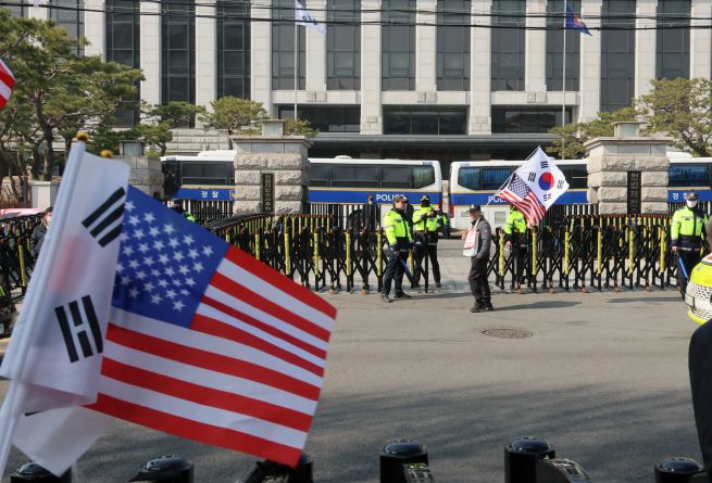 Police officers are stationed in front of the Constitutional Court in Jongno District as South Korea braces for the anticipated impeachment ruling on President Yoon Suk-yeol, which could be announced as early as this week. (Yonhap)