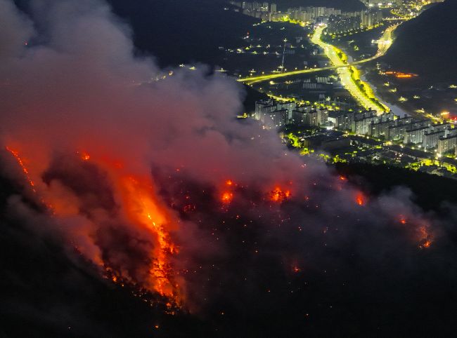 A wildfire rages near a residential neighborhood in the southeastern city of Daegu on April 29, 2025, following its outbreak the previous day on Mount Hamji in the city. (Image courtesy of Yonhap)