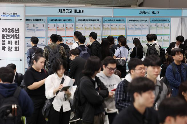 Job seekers examine job postings at the 2025 Mid-Sized Enterprise Job Fair held last month at COEX in Gangnam District, Seoul. (Yonhap)