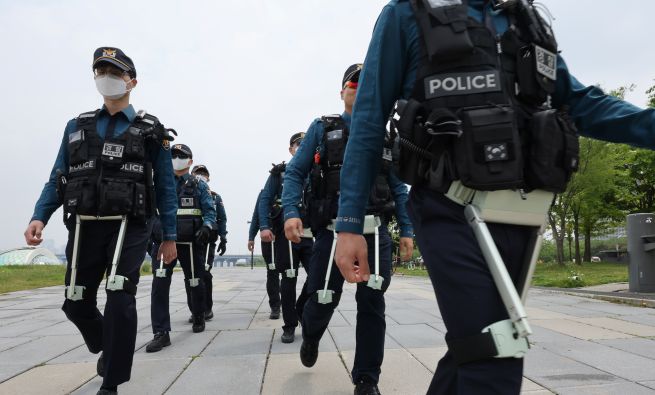 On May 11, at Yeouido Hangang Park in Seoul, members of the Seoul Metropolitan Police’s mobile unit conduct a patrol demonstration while wearing wearable robots. The robotic device, “WIM,” is designed to assist lower body movement and reduce physical strain. The National Police Agency plans to pilot the “K-Smart Policing” program—featuring advanced equipment such as drones, wearable robots, and electric bicycles—through June. (Yonhap)