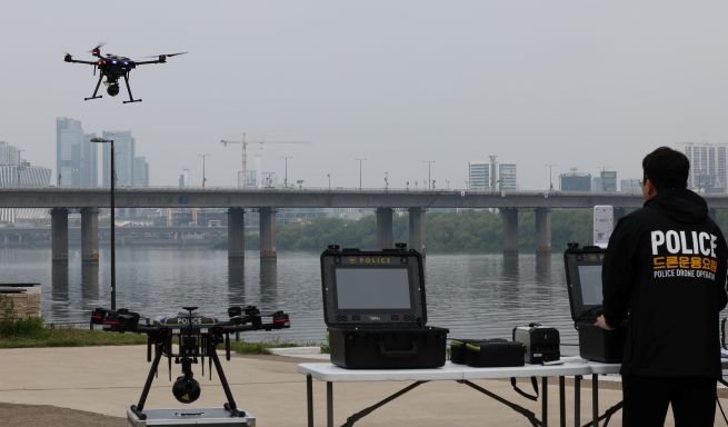 On May 11 at Yeouido Hangang Park in Seoul, an official from the Seoul Metropolitan Police demonstrates a patrol using a drone equipped with thermal imaging capabilities. The National Police Agency is piloting the “K-Smart Policing” program—utilizing advanced technologies such as drones, wearable robots, and electric bicycles—through June. (Yonhap)