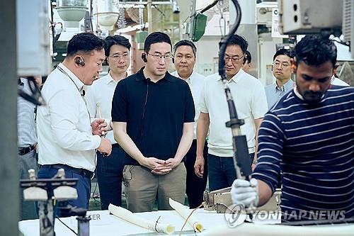 This file photo provided by LG Group shows Chairman Koo Kwang-mo (3rd from L) examining a production line at LG Electronics Inc.'s Noida manufacturing plant in New Delhi in February 2025. (Yonhap)